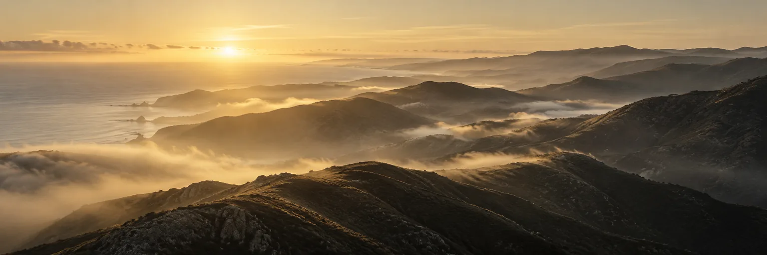Golden morning light over layers of misty hills